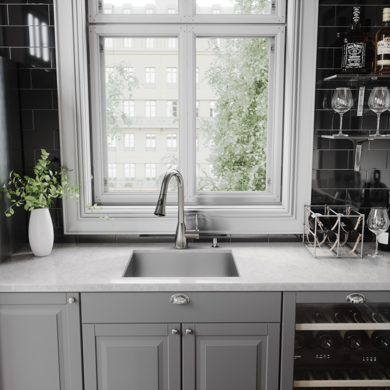 A glossy black tiled backsplash above a moden kitchen sink and kitchen faucet